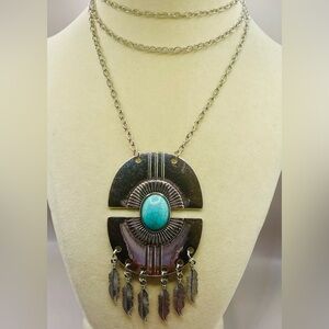 Silver tone necklace featuring a large pendant w/ a turquoise stone centerpiece